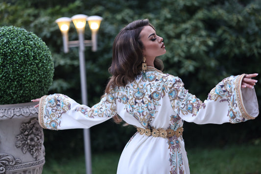 Une femme élégante portant un caftan marocain de luxe, avec des motifs complexes et des couleurs éclatantes..
